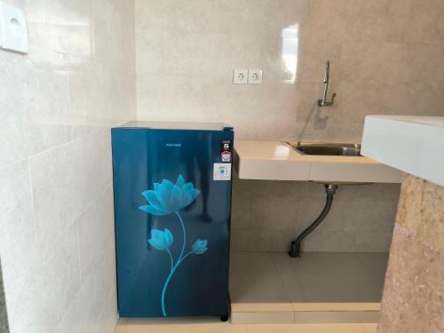 乌布彭杜克巴布家园酒店的带水槽的浴室内的蓝色冰箱