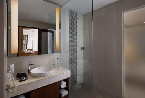沙努尔沙努尔塔克苏酒店的一间带水槽和玻璃淋浴的浴室