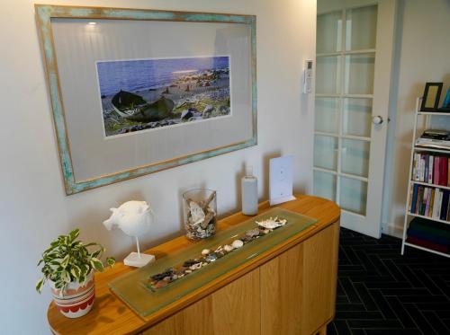 黄金海岸3 Waters Guest Accommodation的一间设有木柜的客房,墙上挂着一幅画