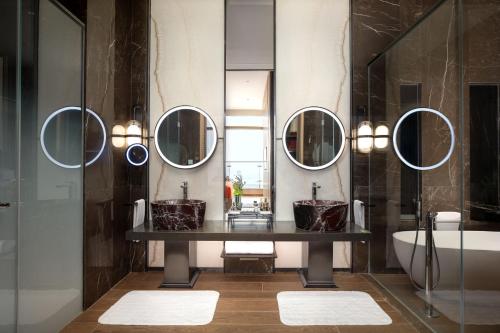 广州广州卓美亚酒店的浴室配有2个盥洗盆、浴缸和镜子