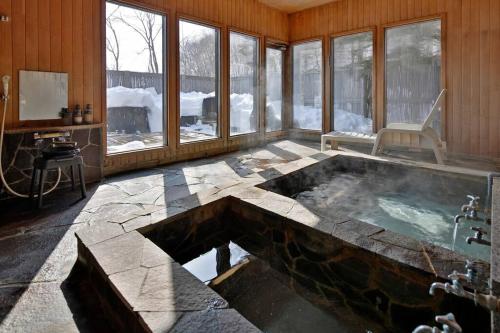 KawayuThe VILLA ABASHIRI的带窗户的客房内设有带热水浴池的浴室
