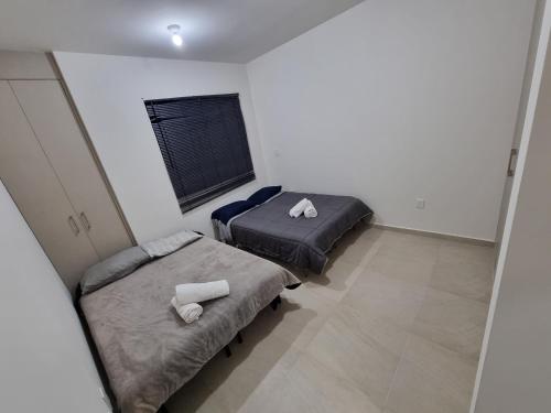 克雷塔罗Casa con alberca Mirador SD的带窗户的客房内设有两张单人床。