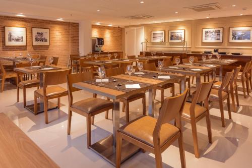 劳鲁-迪弗雷塔斯萨尔瓦多机场城际酒店的配有木桌和椅子的餐厅