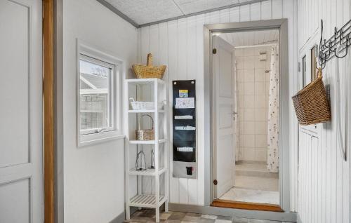 宝可波Stunning Home In Brkop With Wifi的一条有白色墙壁的走廊和一扇带架子的门