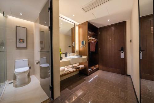 重庆重庆大世界君亭酒店(解放碑店)的一间带卫生间、水槽和镜子的浴室