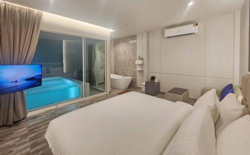 Ban Khlong Lat Bua KhaoSkyline Resort的一间卧室配有一张大床、一个浴缸和一台电视。