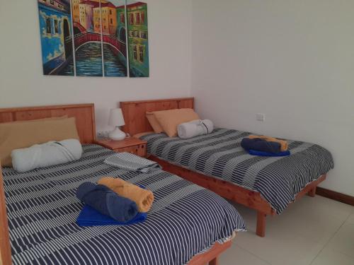 MġarrEast Breeze Penthouse的两张睡床彼此相邻,位于一个房间里