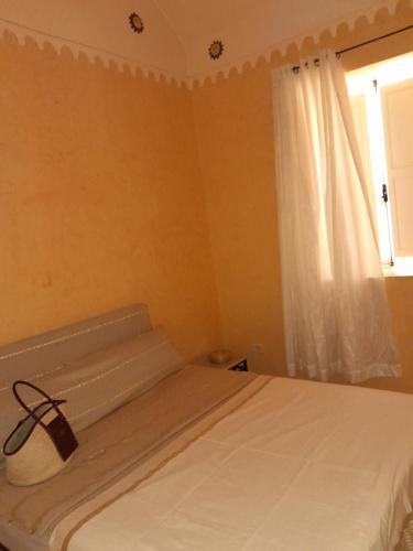 乌姆苏克Dar Rita的卧室配有白色的床和窗户