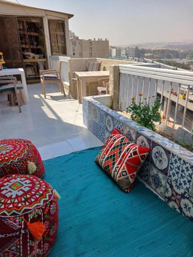 Qaryat ash ShamālīGEM VIEW ROOMS的阳台配有蓝色地毯上的枕头。