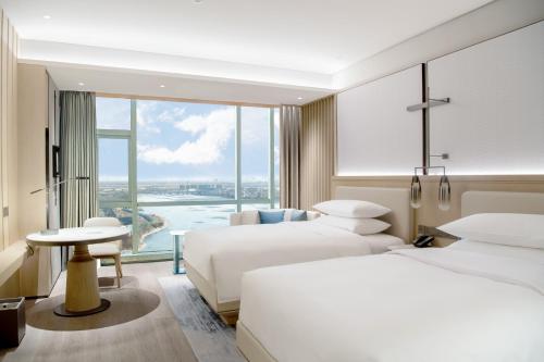 青岛青岛胶州万豪酒店的酒店客房设有两张床和大窗户。