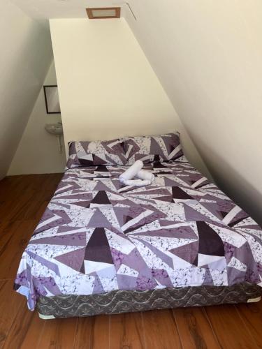 圣胡安Fun Da House的客房内的一张带紫色棉被的床