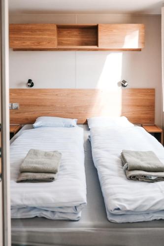 贝尔多夫Pivoine Camping Belle-Vue 2000的客房内的两张床和毛巾
