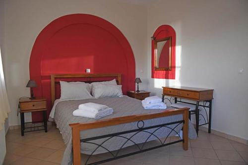 阿梅尼斯蒂斯Villa Christina的一间卧室配有一张大床和红色床头板