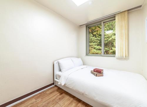 束草市HK Resort的白色的卧室设有床和窗户