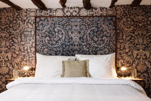 圣埃乌拉利亚Finca Legado Ibiza的一间卧室设有一张大床和锦 ⁇ 墙