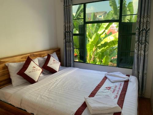 万荣Vang Vieng Lily Guesthouse的一间卧室设有一张大床和大窗户