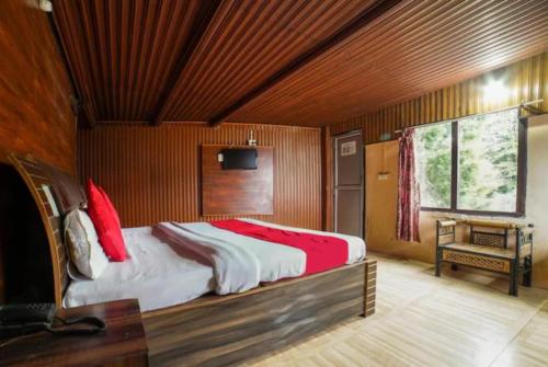 奈尼塔尔Goroomgo Long View Retreat Nainital的一间卧室配有一张带红色枕头的大床