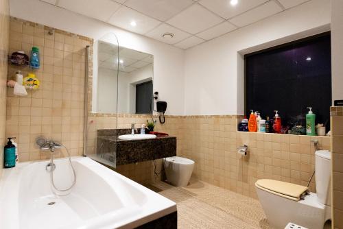 迪拜Nirvana Home的带浴缸、卫生间和盥洗盆的浴室
