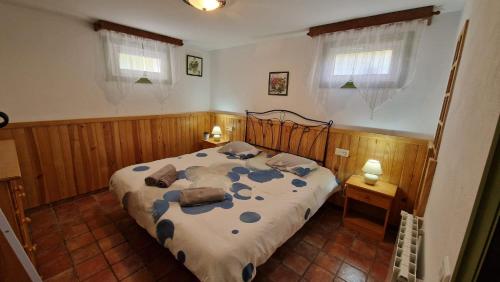 TurísEl Refugio的一间卧室设有床、两张桌子和两个窗户。