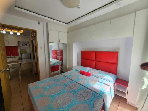 达沃市JFive Homes @ 8Spatial_B2的一间卧室配有一张红色床头板的床