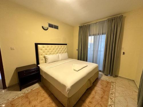 阿吉曼Safari Hotel Apartments的一间卧室设有一张大床和一个窗户。