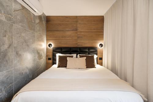 特拉维夫Mulan Hotel的一间卧室配有一张大床和木制床头板