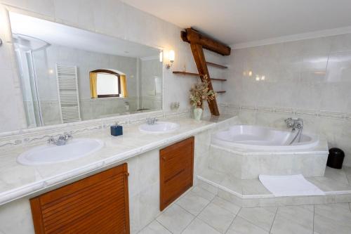 日恰尼中枢膳食公寓的一间带两个盥洗盆和大镜子的浴室