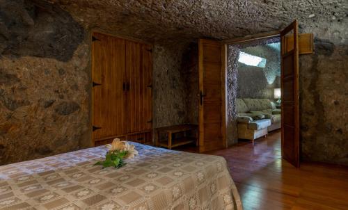 阿尔特纳拉拉斯玛格丽塔卡萨窑洞度假屋的一间卧室,床上有花瓶