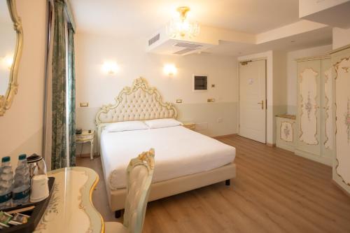 基奥贾Duomo Boutique Hotel的卧室配有白色的床和吉他