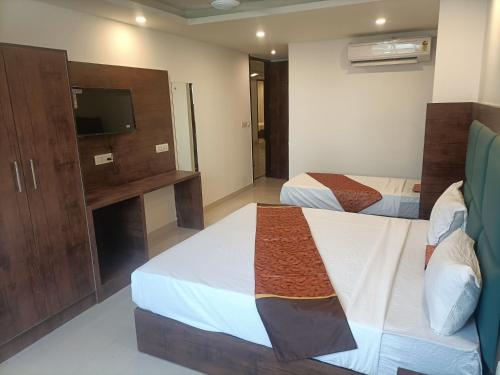 新德里Hotel D Tark Near IGI Airport的一间酒店客房,设有两张床和电视