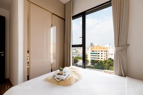胡志明市Exclusive D1mension in District 1 3BR Apartment FreePoolSaunaGym的一间卧室设有一张大床和大窗户
