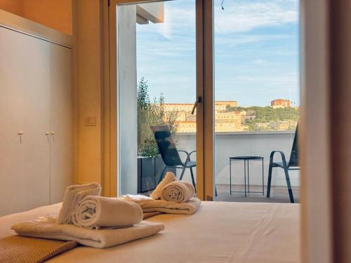 卡利亚里Mameli View Cagliari的一间带毛巾的卧室,卧室配有一张位于床上的阳台