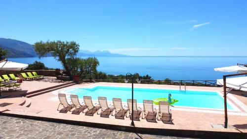 韦兰迈尔Villa Le Cannicelle的一个带椅子的游泳池,背景是大海