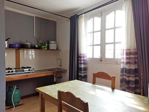 塔那那利佛Chez Jeanne Chambre d'Hôte的厨房配有桌子、窗户和桌椅