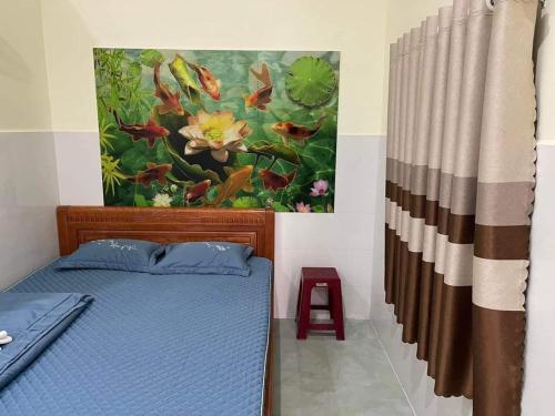 Dồng XoàiNhà trọ Hương Nguyên的卧室配有蓝色的床和墙上的绘画作品
