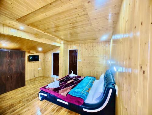 帕哈尔加姆Lady Pahalgam Resort Operated By Zaara Resorts的木墙客房的一张床位