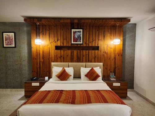 西姆拉The Golden Hotel的一间卧室配有一张带木墙的大床