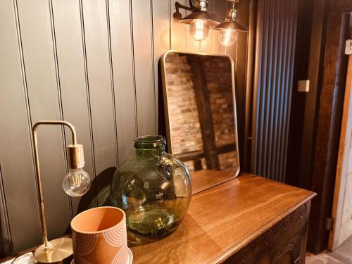 布里格Cobblers Cottage Brigg的木桌上的玻璃花瓶,带镜子