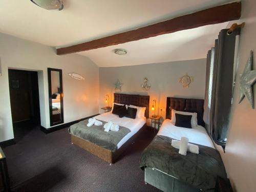 滨海韦斯顿Bay view rooms at Mentone Hotel的一间卧室设有两张床和大镜子