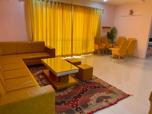 乌代浦Royal Rajvilas Heights的客厅配有黄色窗帘、沙发和椅子