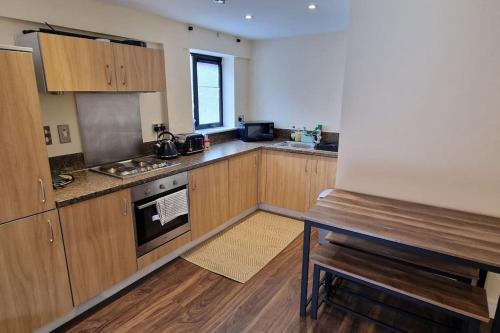 伯明翰Two Bedroom Flat B1 Birmingham ( Parking )的厨房配有木制橱柜和炉灶烤箱。