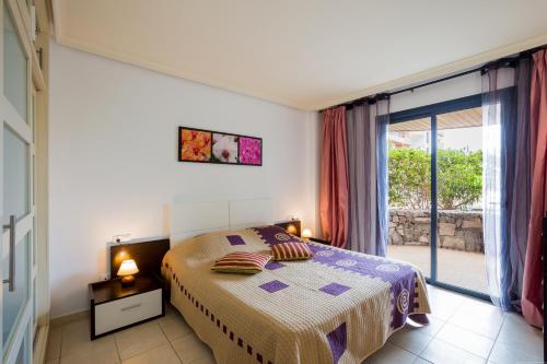 圣地亚哥港Balcon De Los Gigantes的一间卧室设有一张床和一个滑动玻璃门