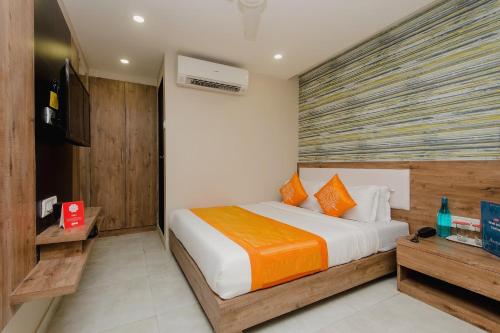 孟买OYO Hotel Blue Ocean Near R City Mall的一间卧室配有带橙色和白色枕头的床
