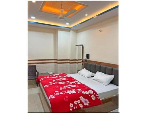 坎普尔Hotel Shree Galaxy, Kanpur的一间卧室配有一张带红色毯子的床