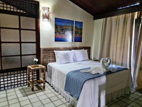 塔曼达雷Hotel Praia dos Carneiros的一间卧室设有一张床和一个窗口