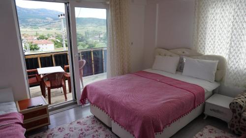 YeşilovaSalda Karanfil Pansiyon的一间卧室设有一张床和一个大窗户