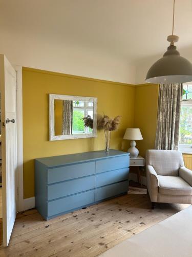 伯恩茅斯Palm - Bournemouth的客厅配有蓝色梳妆台和椅子