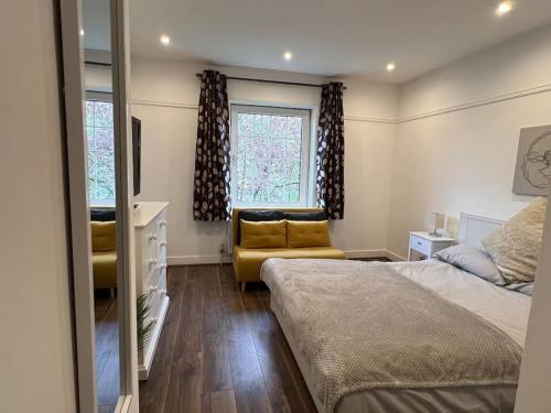 伦敦3 Bed luxury house, 10 min walk to underground的一间卧室配有一张床、一张沙发和一个窗口