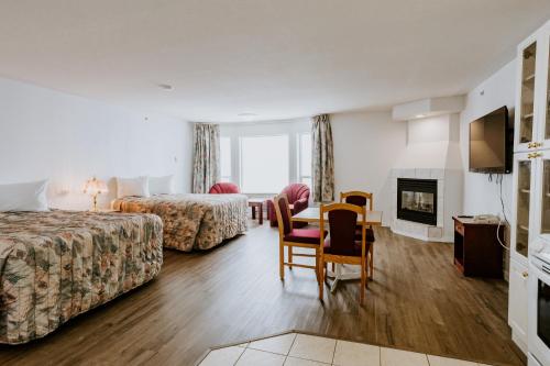 雷德迪尔Mosaic Suites的酒店客房带两张床和一张桌子以及椅子。