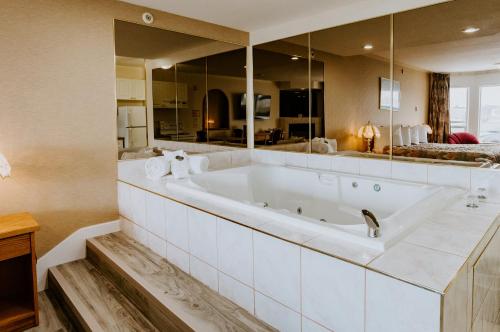 雷德迪尔Mosaic Suites的设有带大镜子的浴室的大浴缸